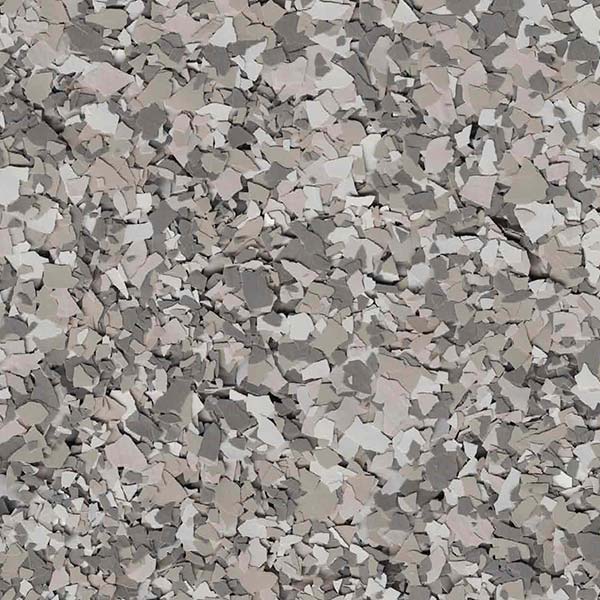 A textured surface composed of variously sized and colored chips, primarily in shades of gray and beige, creating a random pattern.