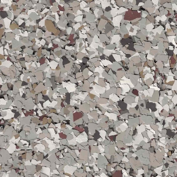 A close-up of a textured surface featuring randomly scattered, multicolored flakes in shades of gray, white, and brown.