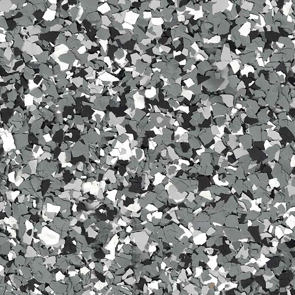 Close-up of grey, black, and white decorative floor flakes in a random, speckled pattern, commonly used for garage floors or industrial surfaces.
