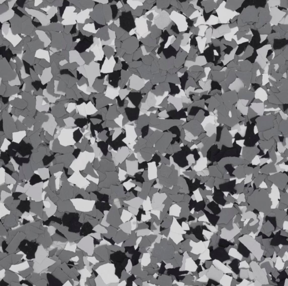 The image depicts a close-up of a textured surface with irregular, multicolored fragments in shades of black, gray, and white.